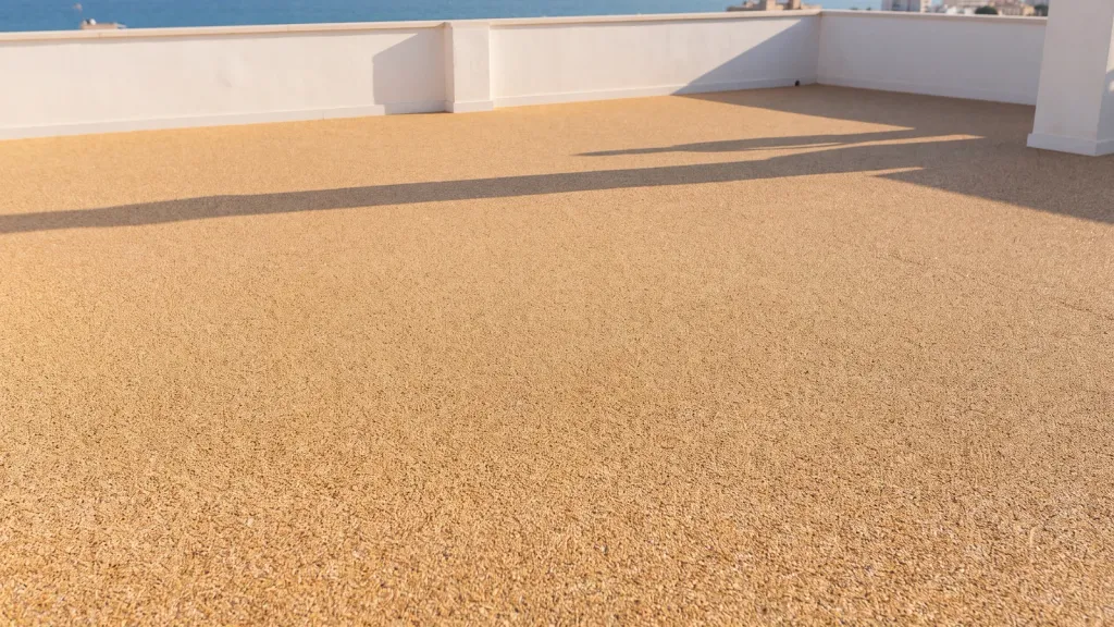 Azotea con stone carpet y vistas al mar: pavimento continuo de árido en toda la superficie